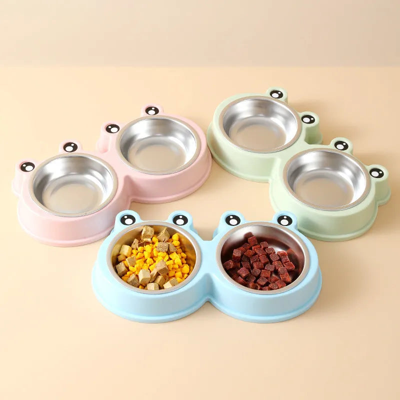 Frog-shaped plastic holder containing two stainless steel pet bowls for food and water.