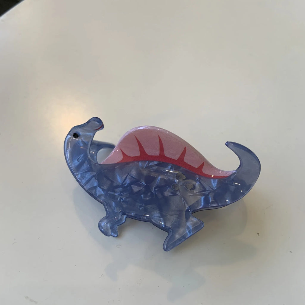 Acrylic hair clip with dinosaur design in various colours including blue, brown, green, pink and purple variants