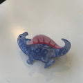 Acrylic hair clip with dinosaur design in various colours including blue, brown, green, pink and purple variants