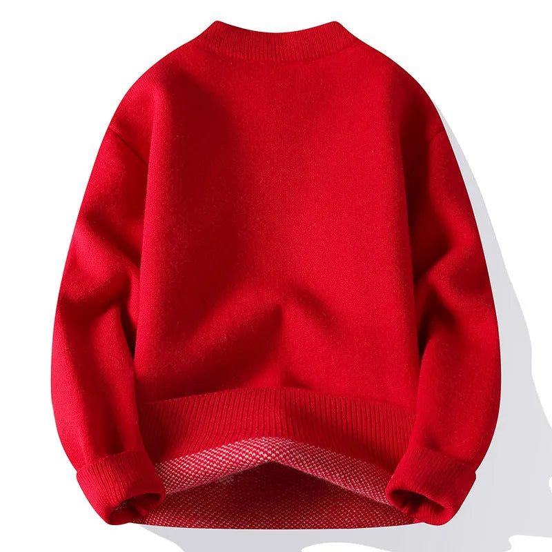 Man wearing a loose grey knitted pullover jumper with a ribbed hemline.