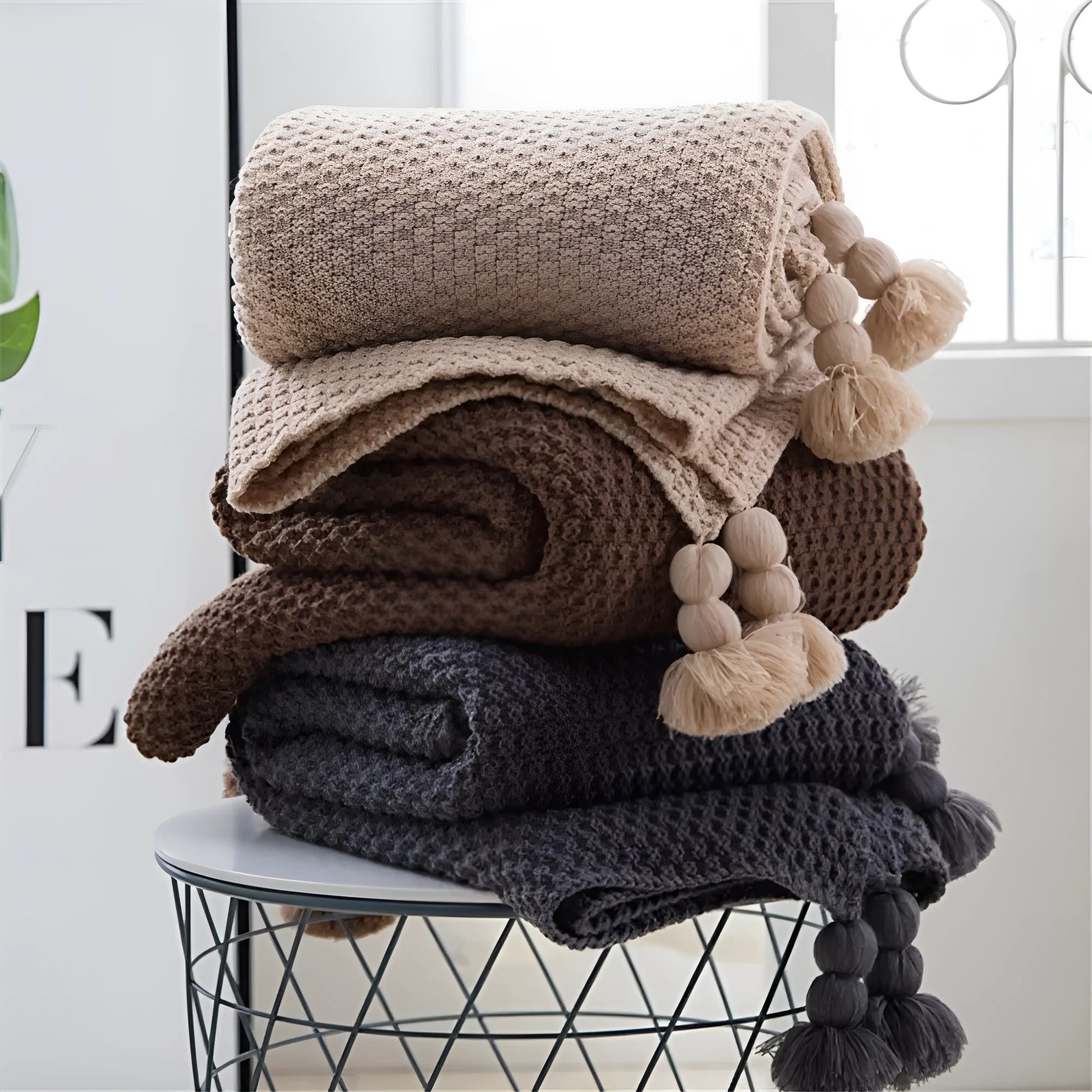 Nordic-style fringed knit acrylic blanket in a neutral colour, laid flat showing its 130x170cm size.