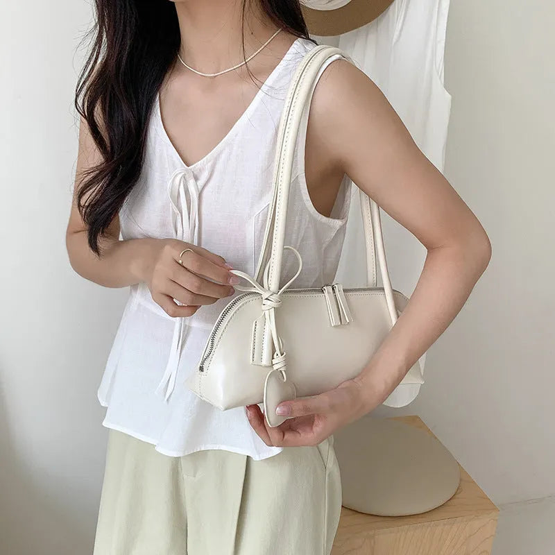Crossbody shoulder bag in black PU with double straps, horizontal square shape, and visible sewing thread detail on front