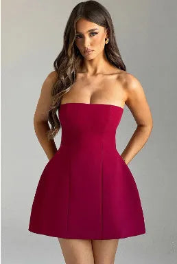 A woman wearing a solid colour backless A-line tube dress with a high waist and short skirt.