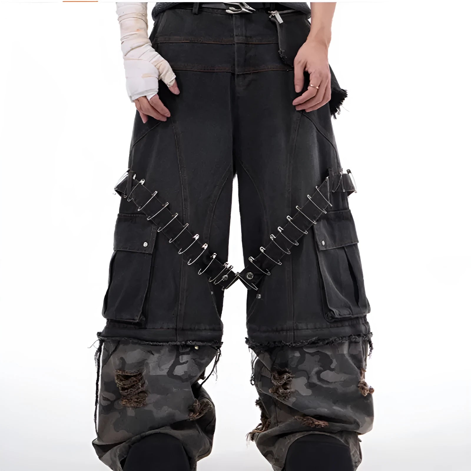 Grey men's jeans with camouflage pattern and spliced construction, showing pin and ribbon details.