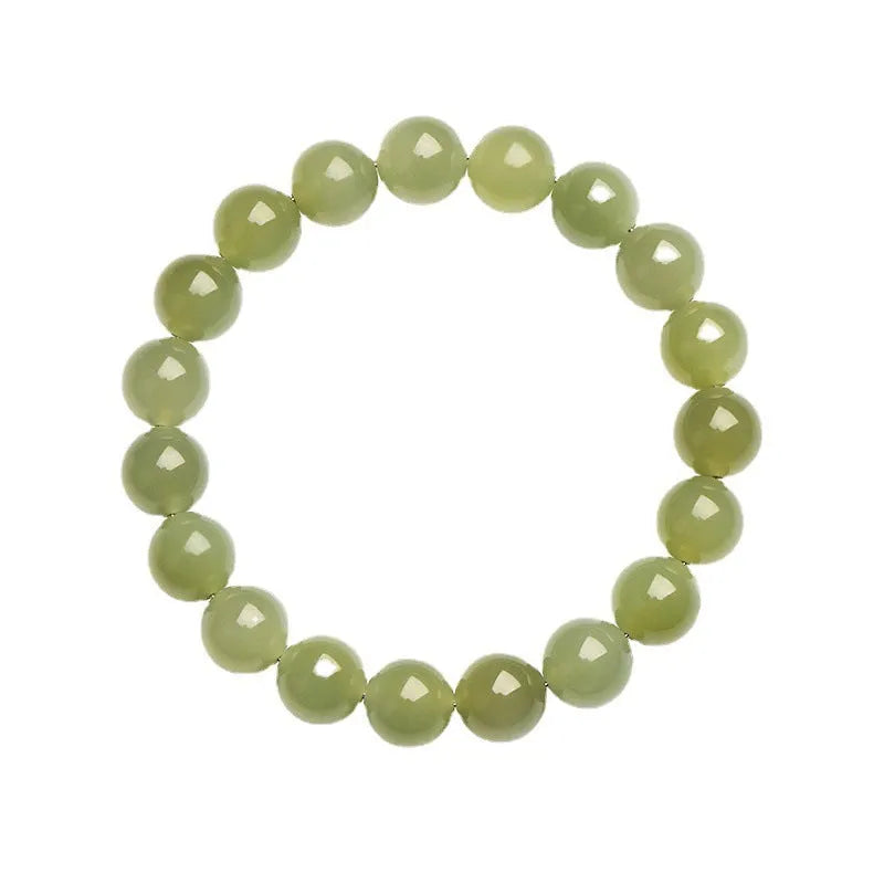 A polished Hetian Jade ball bracelet in a clear water colour on a wrist, showing spherical beads.