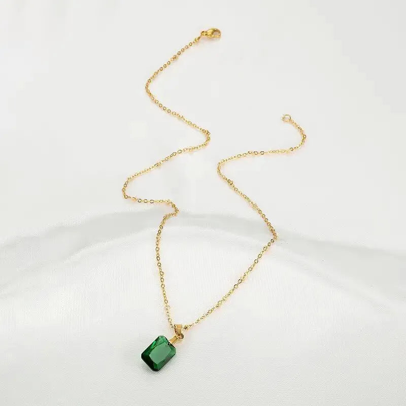 Copper geometric necklace with rectangular green pendant on an O-ring chain.