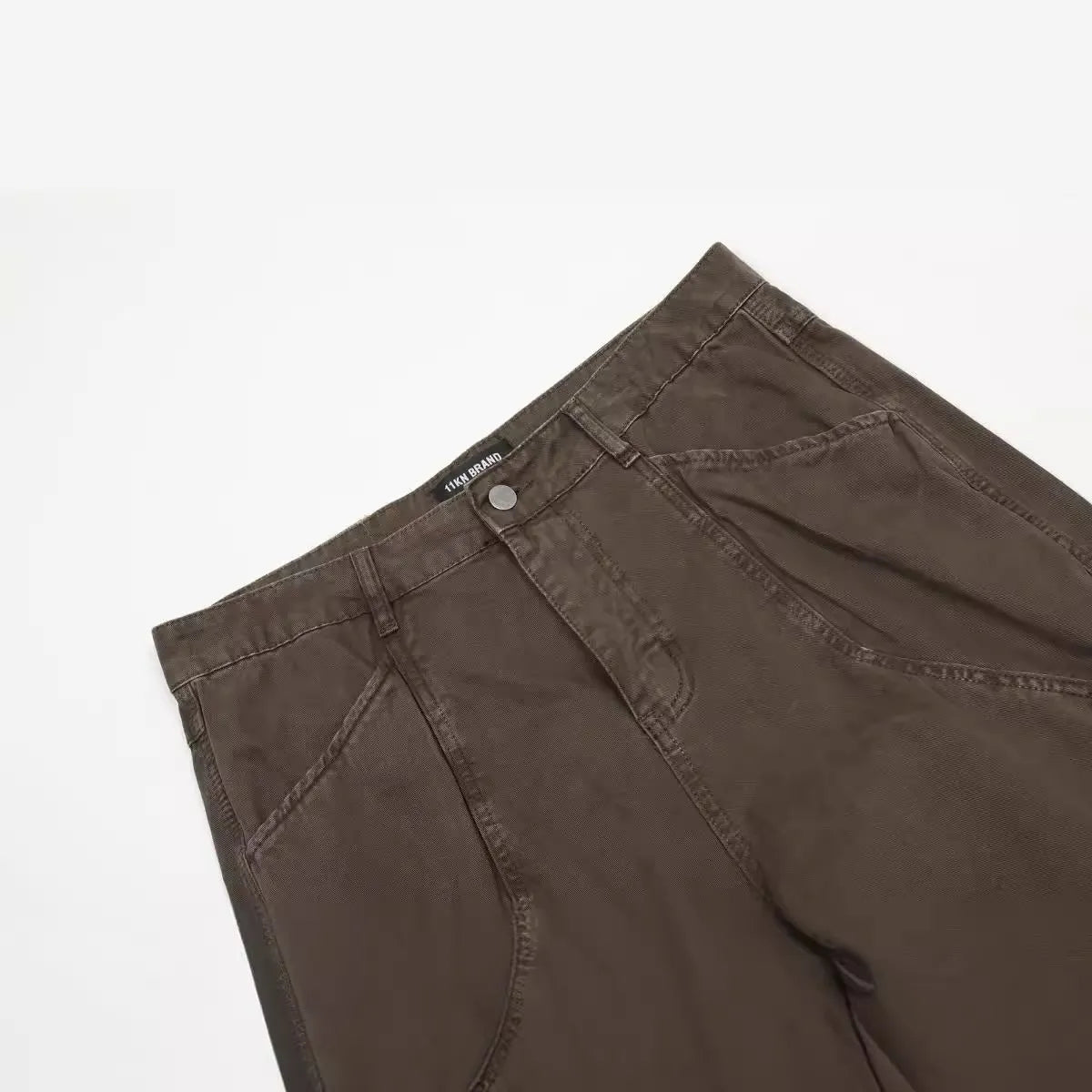Men's brown loose straight leg trousers with high waist design and zip fly closure