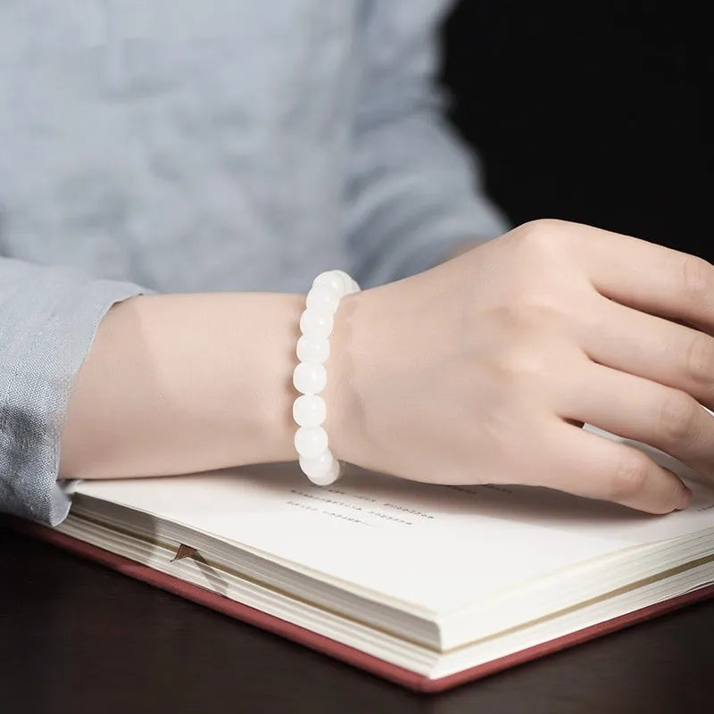 White Hetian jade barrel bead bracelet shown in three bead size variations on a wrist.