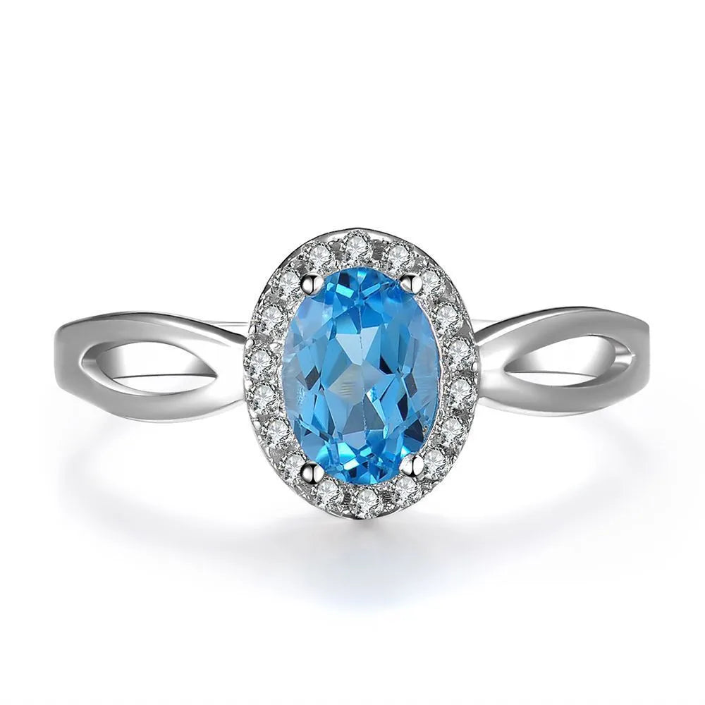 Women's 925 silver blue topaz jewellery set showing geometric earrings, ring, pendant and necklace.