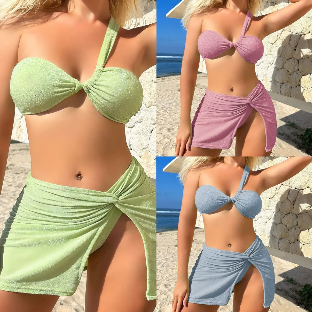 Women's light green one-shoulder swimsuit top with matching skirt and pants on a hanger.