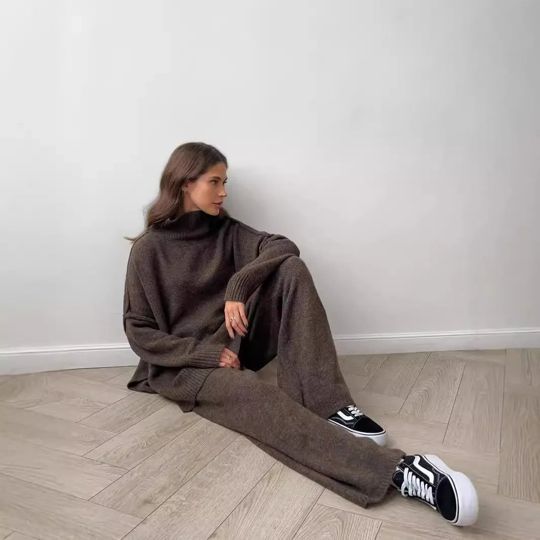 Women's knitted acrylic suit set with side-slit top and matching trousers in a solid colour.