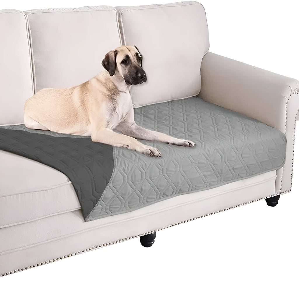 Reversible grey and burgundy waterproof dog blanket laid flat on a sofa.