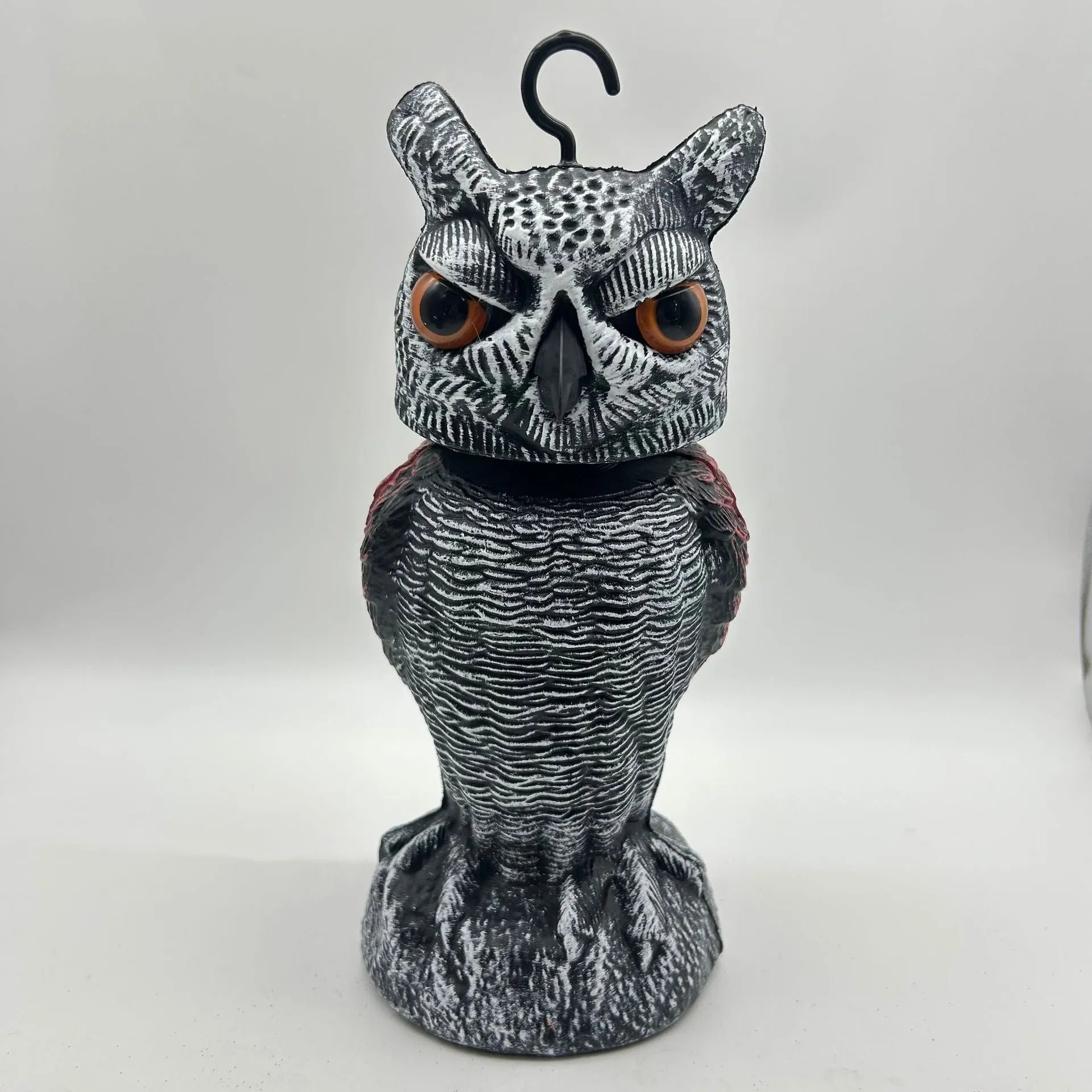 Artificial owl bird scarer decoy with shaking head motion in outdoor setting