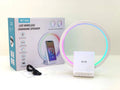 White smart Bluetooth speaker with wireless charging pad and ambient lighting on desktop
