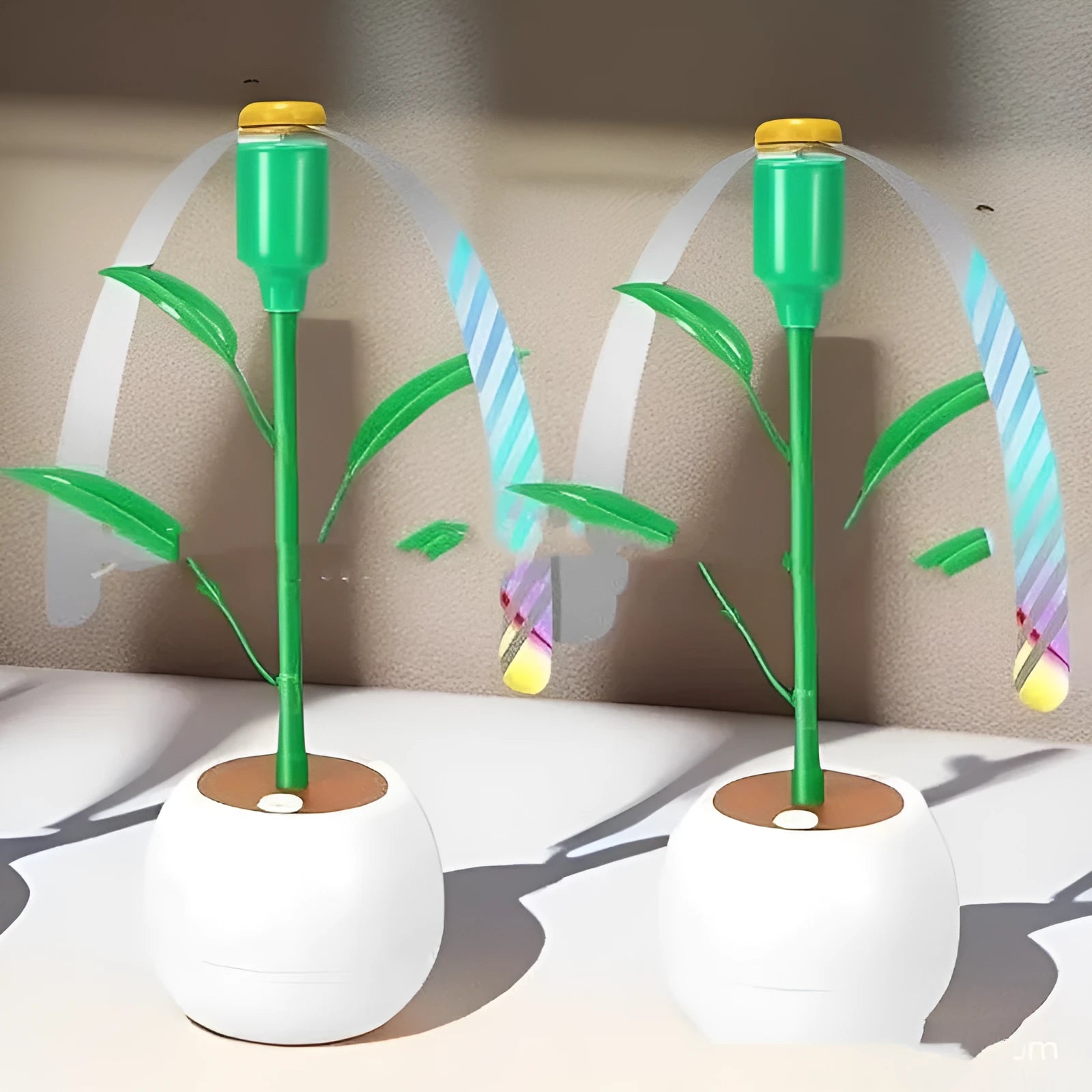 White battery fly repellent fan with curved hose and fruit-shaped design on outdoor table