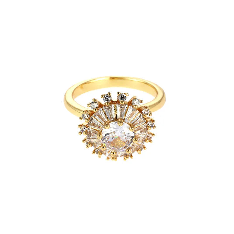 Gold electroplated copper flower ring with open mouth design on a plain background