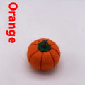 Wool felt pumpkin-shaped doll decorations in autumn colours on a neutral background