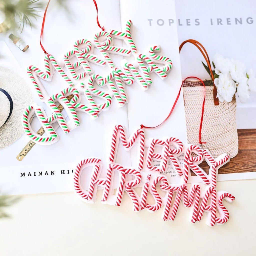Merry Christmas letter plate polymer clay tree ornament in red, white and green plastic hanging on a tree branch