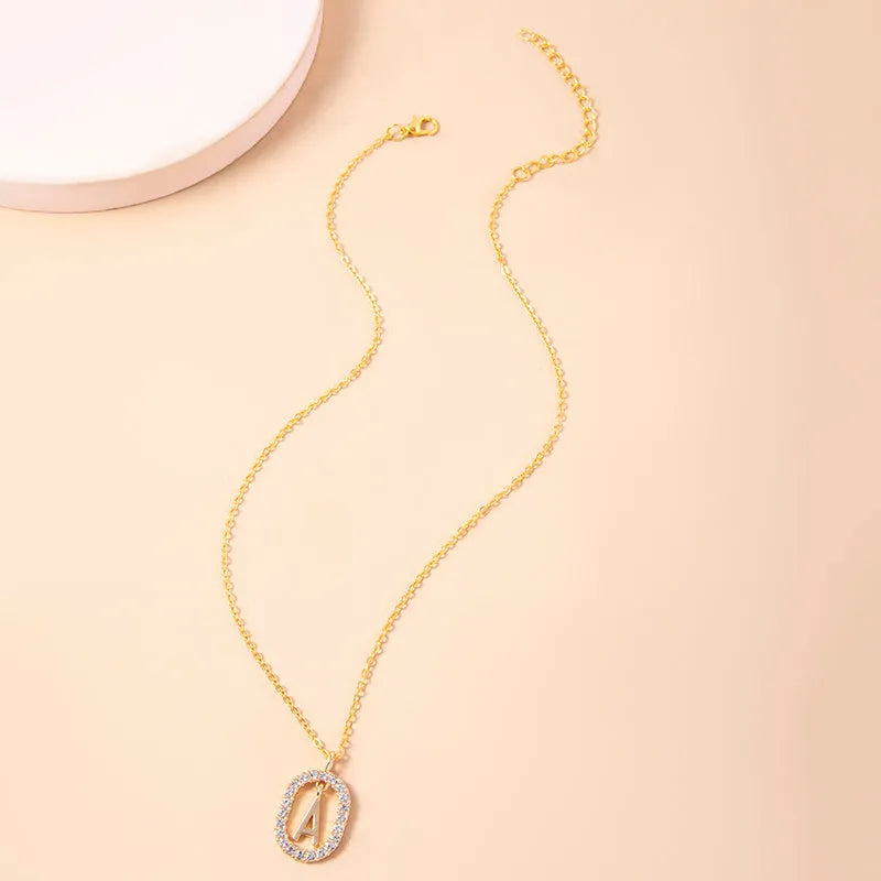 Gold crystal letter initial oval pendant necklace on woman, rhinestone letter in zinc alloy frame with adjustable chain