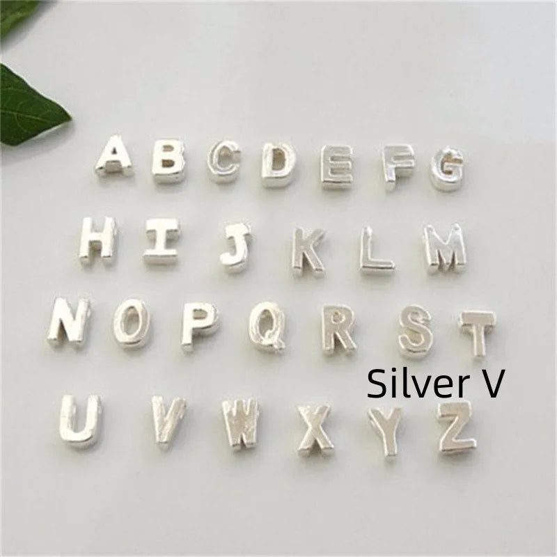 Golden peach heart shaped alloy necklace pendant with a letter design on a white background.