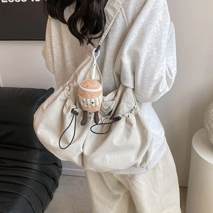 Ultra-light pleated foldable crossbody bag in beige, showing split pocket and crossbody strap.