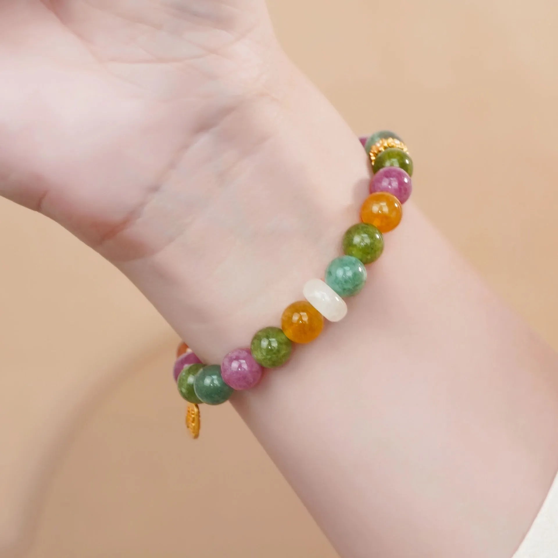 Rainbow colour tourmaline half bracelet for women on a wrist.
