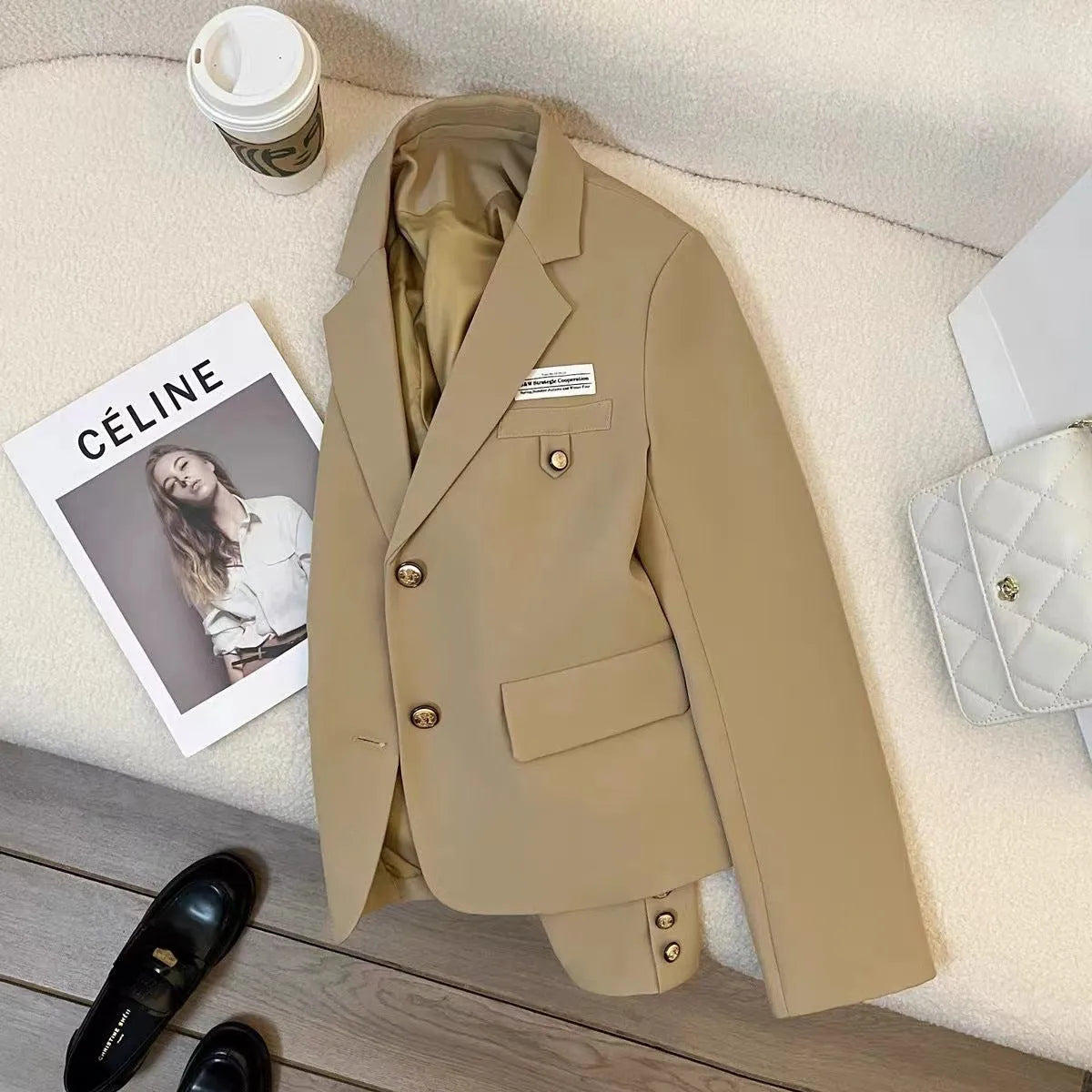 Black women's loose-fit suit coat with long sleeves and a pocket, made from polyester.