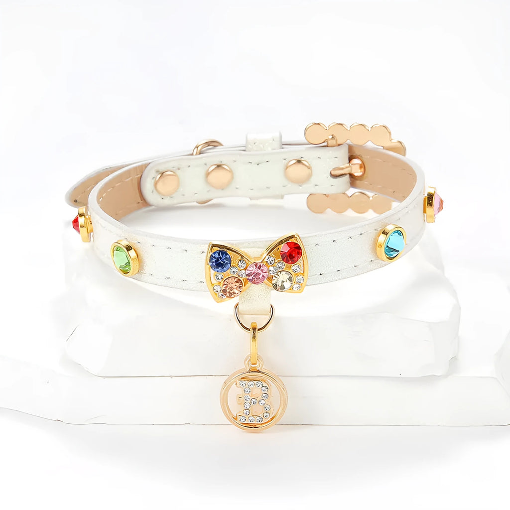 White PU cat collar with diamond alloy bow on a flat surface showing buckle and bow detail