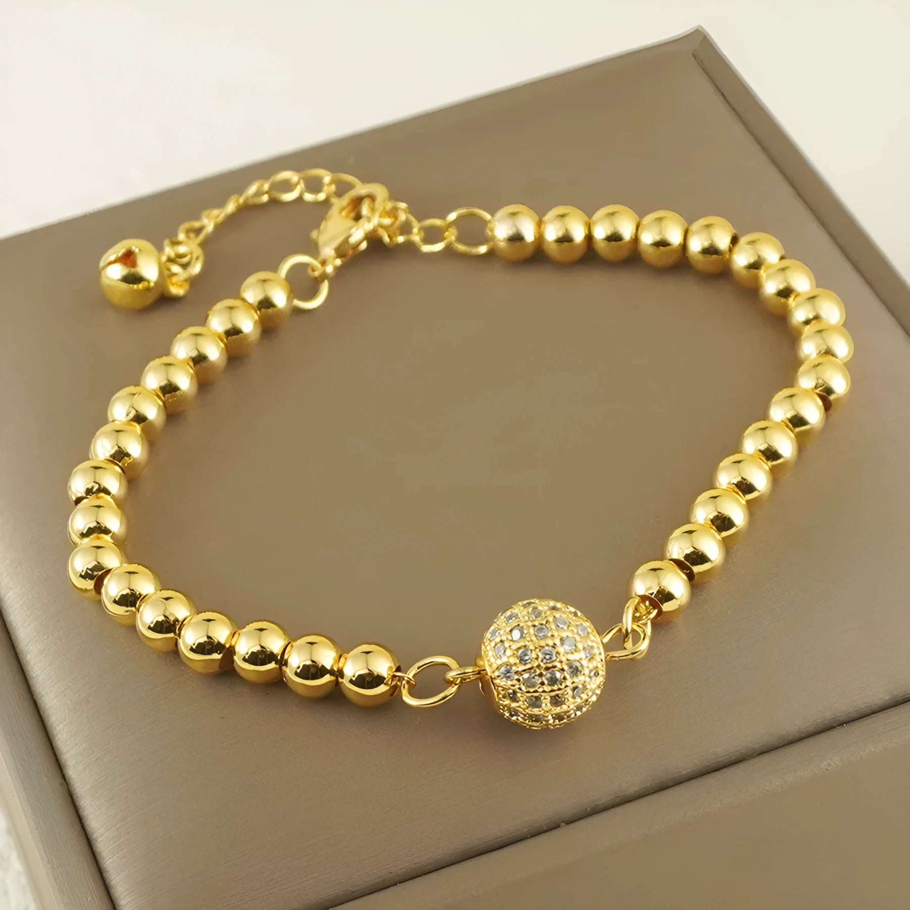 Close-up of a women's copper bracelet with a heart-shaped centre holding a single round zircon stone.