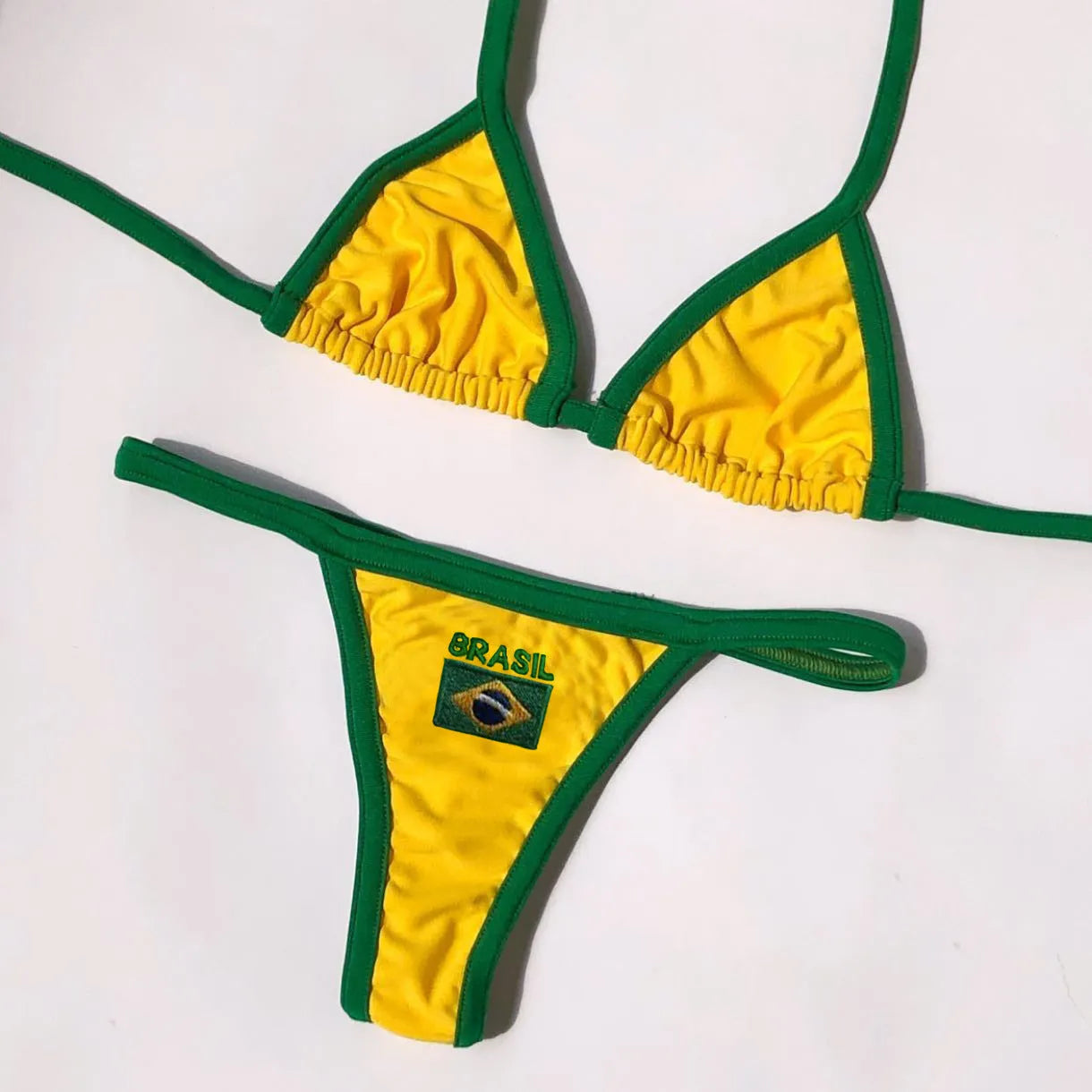 Yellow women's T-back bikini top with matching shorts-length pants on a neutral background.