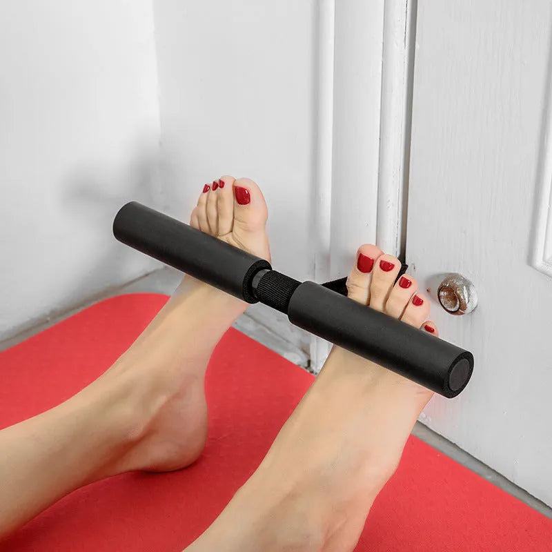 Black portable abdominal fitness device on a flat surface, showing steel frame with foam and PVC handles