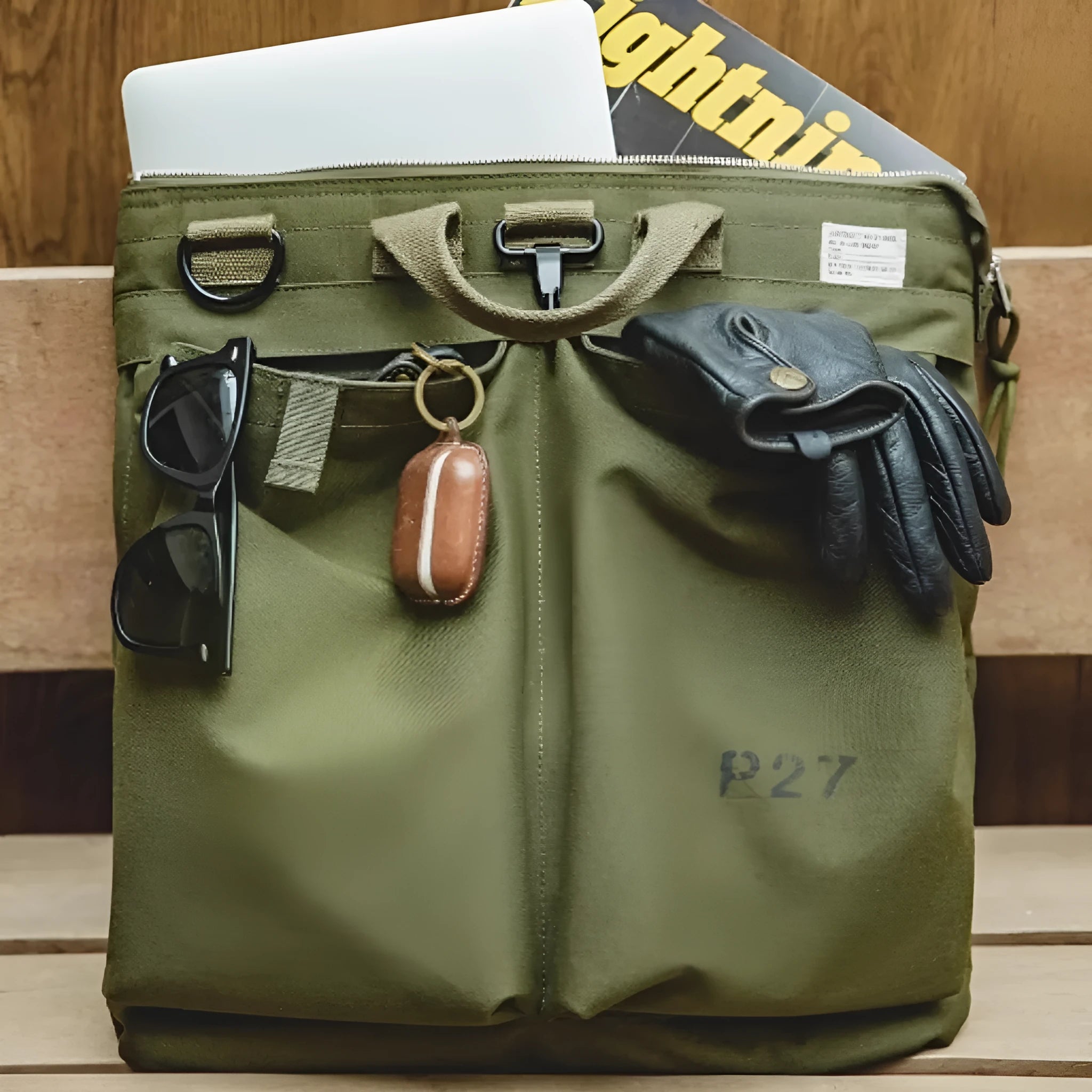 Medium canvas crossbody messenger bag in military green showing laptop compartment and shoulder strap