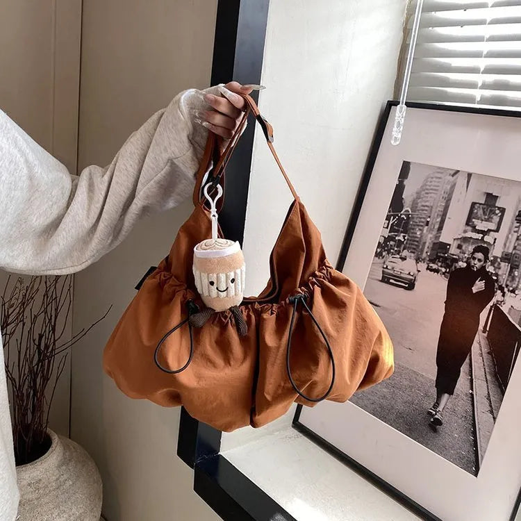 Ultra-light pleated foldable crossbody bag in beige, showing split pocket and crossbody strap.