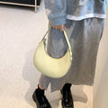 Women's retro dumpling-shaped PU leather shoulder bag in black showing sandwich pockets and zippered compartment