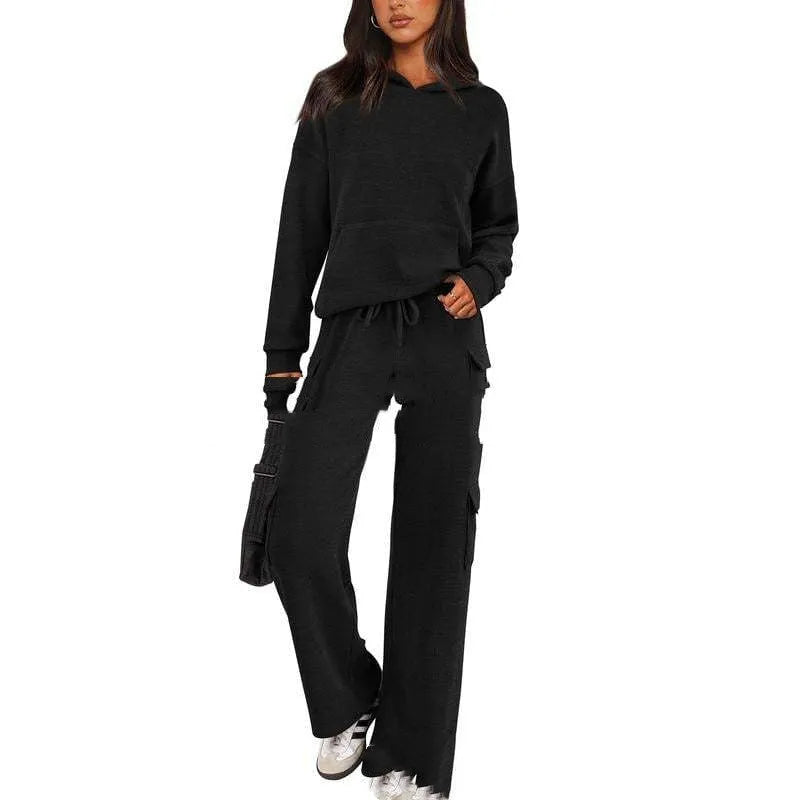 Women's black polyester leisure sports suit set with long sleeves and trousers laid flat.
