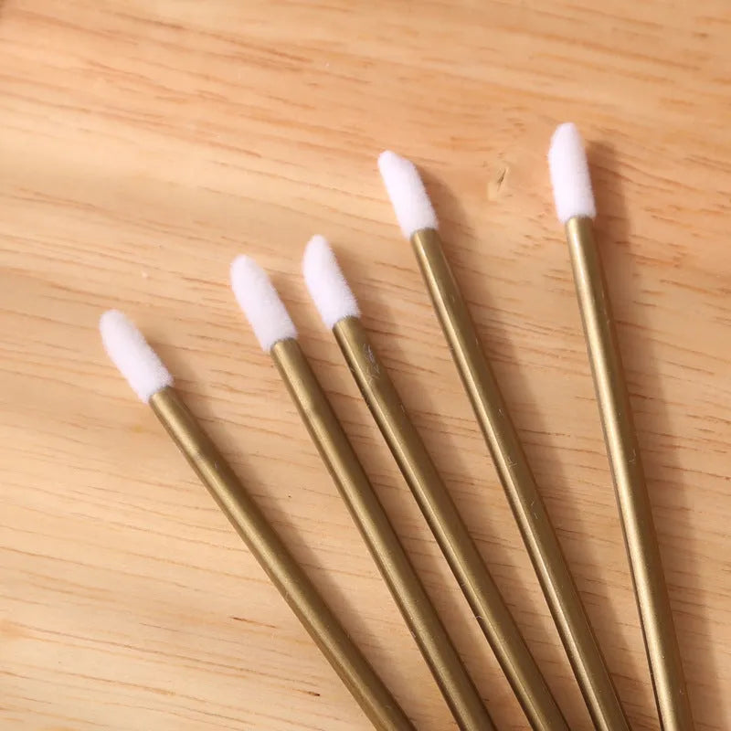 Pack of disposable lip brush applicators with coloured handles and flocked brush tips on a white background
