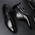 Men's black leather dress shoes with low heel and front strap on white background