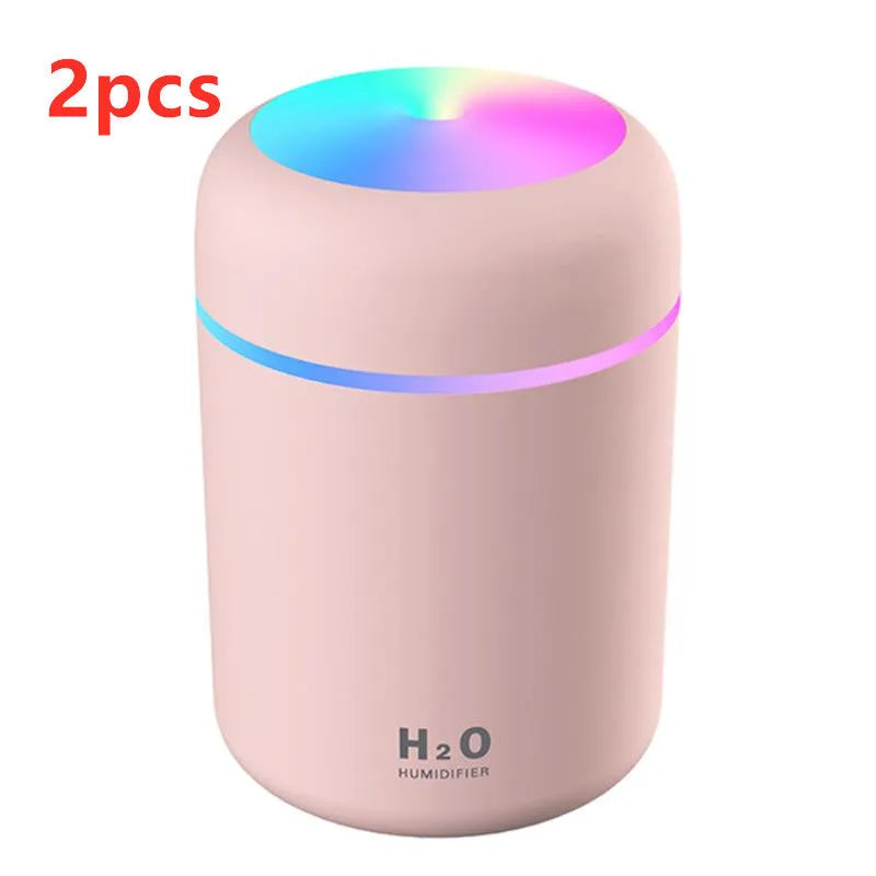 Pink USB desktop humidifier with colourful LED lights and 300ml water tank on wooden desk