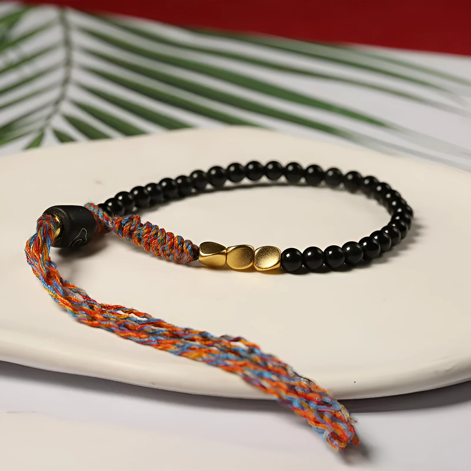 Hand-woven obsidian carrying strap bracelet showing textured weave detail and narrow 4mm width
