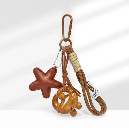 Handmade soda bread handbag pendant ornament with brown carrying strap on a bag.