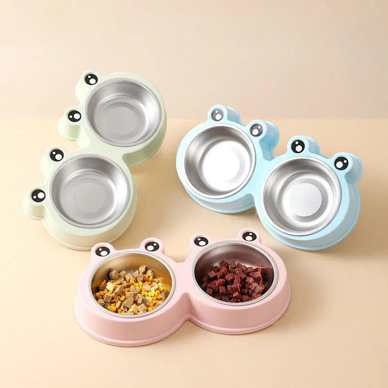 Frog-shaped plastic holder containing two stainless steel pet bowls for food and water.