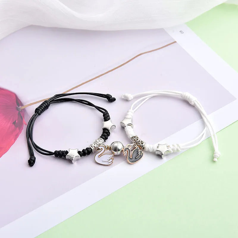 Magnetic clasp couple bracelets with alloy construction and symbolic designs including crown and love lock motifs.