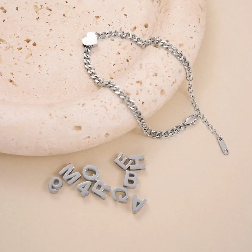 Gold and silver titanium steel initial number necklace with alphabet and number pendants on a 40.5cm chain.