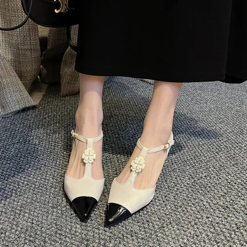 Women's gold stiletto heel shoe with pointed toe, flower buckle, and shallow mouth design on a beef tendon sole.