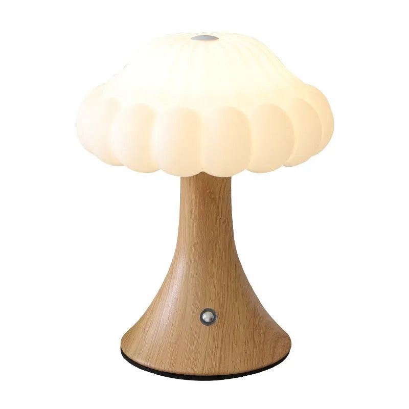 Small mushroom-shaped touch night lamp in wood grain finish on a wooden table.