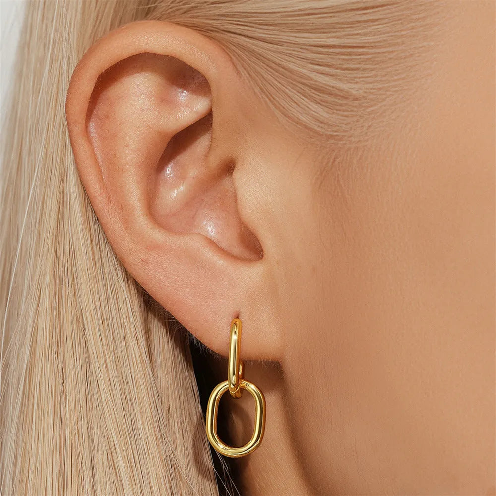 Golden brass earclip earrings with geometric shapes and round elements