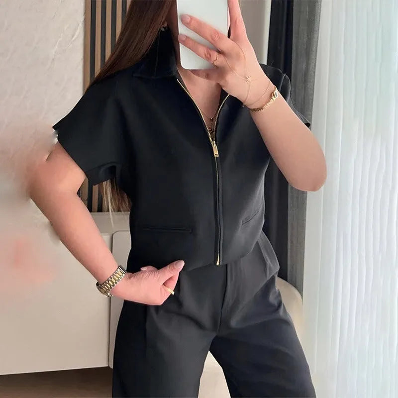 Woman's loose-fit short-sleeve casual top in black polyester fabric on a hanger.