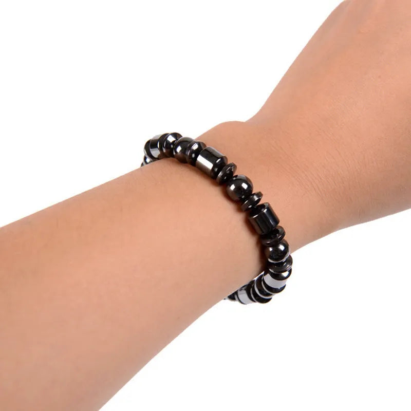 Black pentagram pattern magnetic therapy bracelet with magnetite and hematite stones on a stretch band.