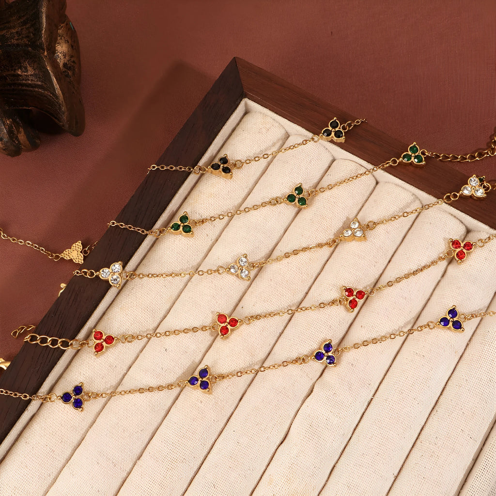 Women's stainless steel geometric bracelet with triangle design and three-diamond centrepiece in gold or steel finish.