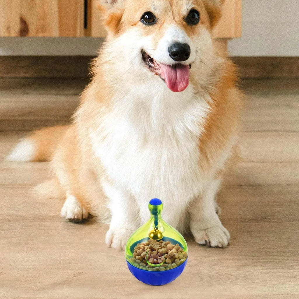 Blue tumbler-shaped pet treat dispenser toy for dogs and cats on wooden floor